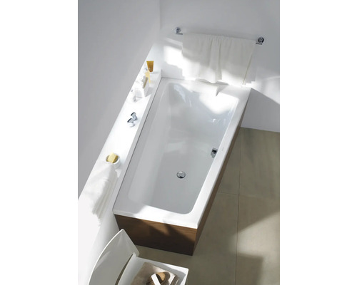 Baignoire rectangulaire avec habillage en bois dans une salle de bain lumineuse