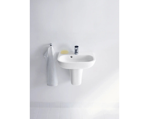 Waschbecken mit Armatur, Seife und Handtuch an einer Wand montiert