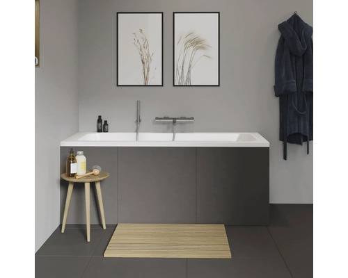 Salle de bain moderne avec baignoire, tapis de bain en bois et décoration