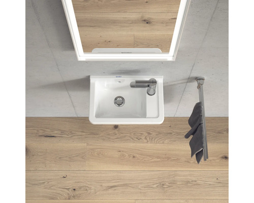 Aufnahme von oben eines Badezimmers mit Waschbecken, Spiegel und Handtuchhalter.