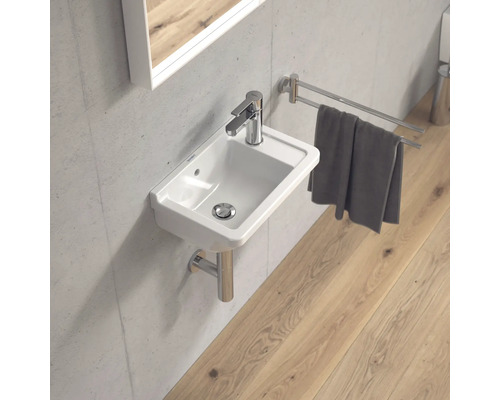 Modernes Badezimmer mit kleinem Waschbecken, Armatur, Handtuchhalter und Spiegel