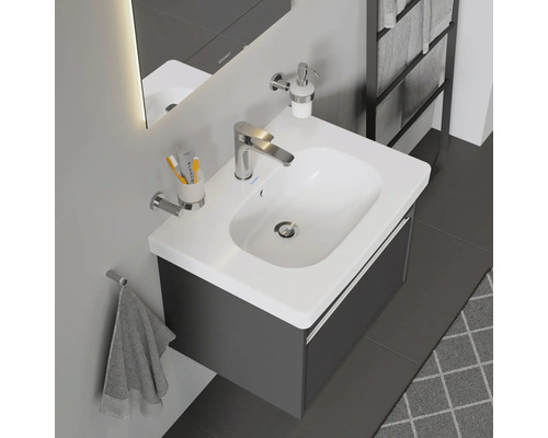 Lavabo avec meuble sous-vasque, robinet, distributeur de savon et porte-serviettes dans la salle de bains