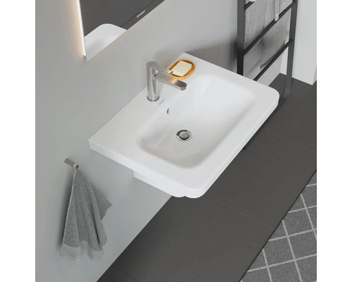 Vasque à poser blanche avec robinetterie, porte-savon et porte-serviettes dans la salle de bains.