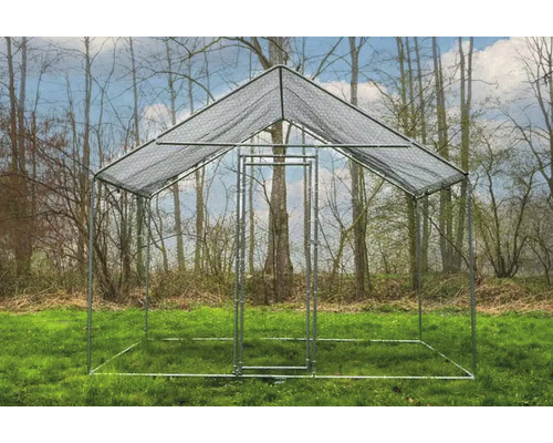 Enclos à poulets autoportant en métal avec toit en treillis métallique dans un pré devant des arbres.