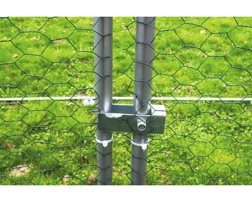 Gros plan d''un grillage à poules avec des poteaux et un treillis métallique.