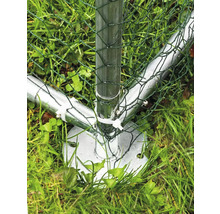 Gros plan d''un poteau de clôture métallique avec un grillage vert dans l''herbe.
