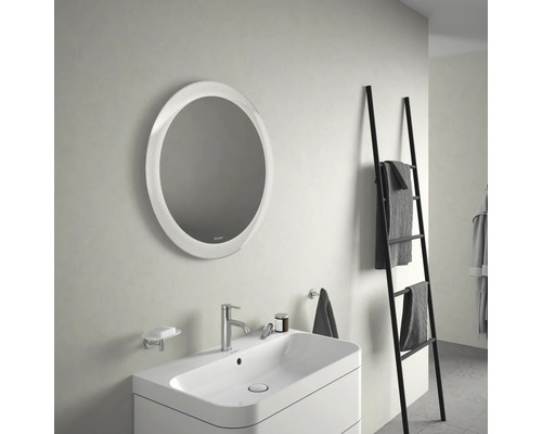 Salle de bains avec miroir rond, lavabo et échelle porte-serviettes