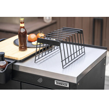 Ablagerost aus Metall auf einer Grillstation mit Flasche, Tomaten und Schneidebrett