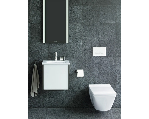Modernes Badezimmer mit Waschbeckenunterschrank, Wand-WC, Spiegel und Armaturen vor dunkler Wand