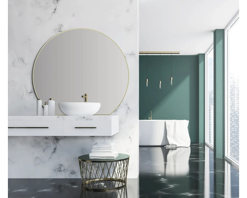 Helles Badezimmer mit Marmorwand, Waschbeckenunterschrank, runder Spiegel und Badewanne