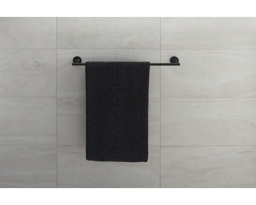 Schwarzer Handtuchhalter mit gemustertem Handtuch an einer Wand