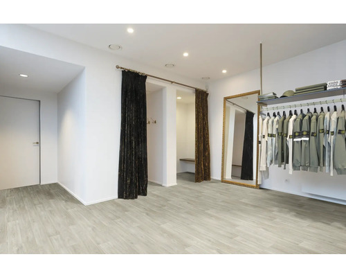 Intérieur d''un magasin de vêtements avec des cabines d''essayage, un miroir et une penderie