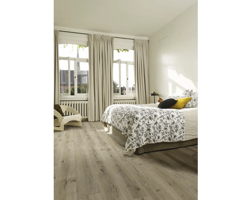 Chambre claire avec lit, rideaux et plancher en bois