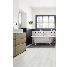 Salle de bains avec baignoire îlot, lavabo et fenêtre pour une ambiance lumineuse.