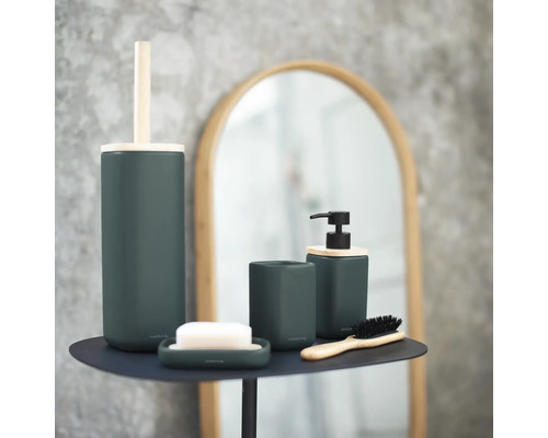 Badezimmer-Set mit Seifenspender, Seifenschale, Zahnputzbecher, Bürste und Toilettenbürste auf einem Tisch vor einem Spiegel