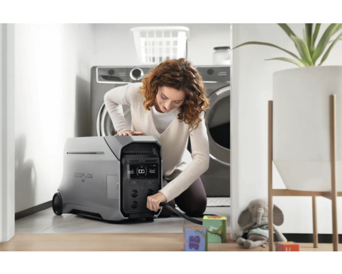 Une femme branche une centrale électrique EcoFlow dans une buanderie