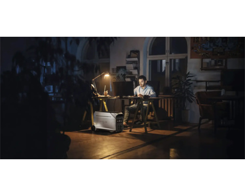 Homme travaille à son bureau avec une centrale électrique portable dans la pièce