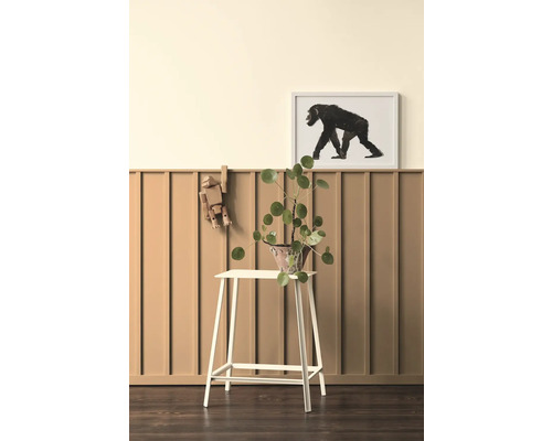 Intérieur décoratif avec plante sur un tabouret, figurine en bois et image de singe encadrée