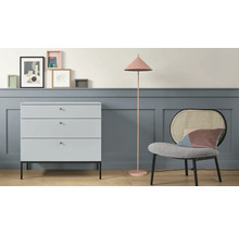 Scène d''ameublement avec commode, lampadaire et chaise devant un mur avec des cadres photo