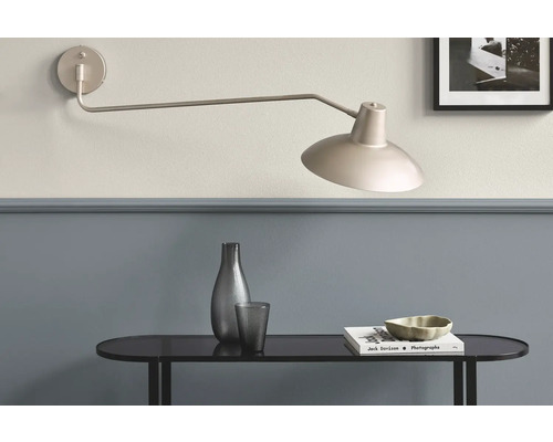 Wandleuchte über einem Tisch mit Dekoration