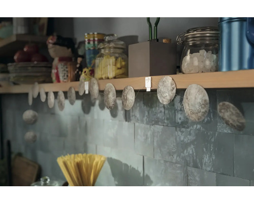 Dekorative Muschelgirlande an einer Küchenwand