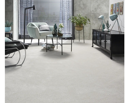 Salon lumineux avec moquette, fauteuil, table et décoration