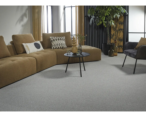 Salon avec moquette grise, canapé d'angle marron et décorations