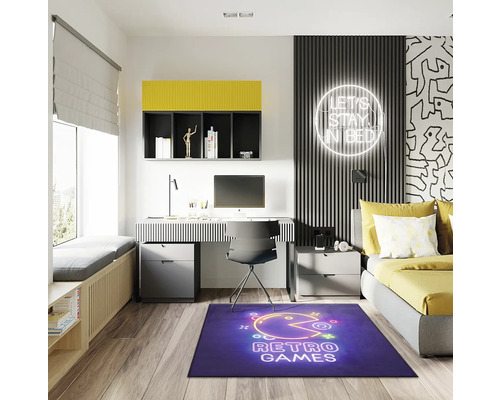 Chambre d''adolescent moderne avec bureau, lit et tapis bleu avec motif de jeux rétro.