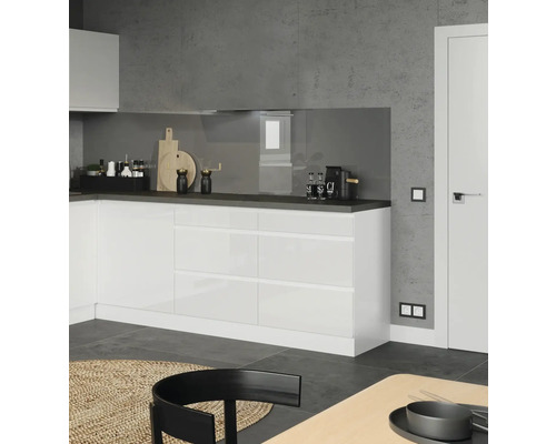 Cuisine moderne avec des armoires blanches, un plan de travail foncé et des décorations.