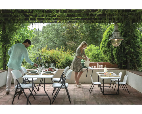 Terrasse mit Gartentischen und Klappstühlen für eine Mahlzeit im Freien