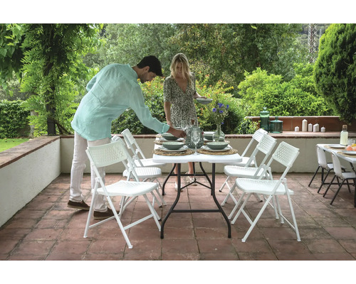 Szene im Freien mit einem Esstisch und Stühlen für eine gesellige Runde.