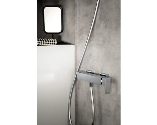 Aufnahme eines Badezimmers mit einer Duscharmatur, einem Spiegel und einer Ablagefläche