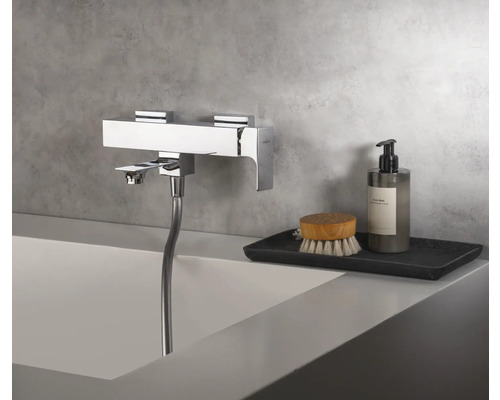 Robinet de baignoire chromé avec douchette au bord de la baignoire