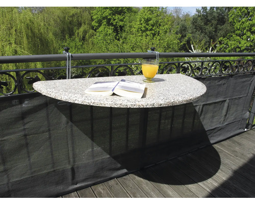 Table de balcon avec boisson et livre fixée à une balustrade de balcon