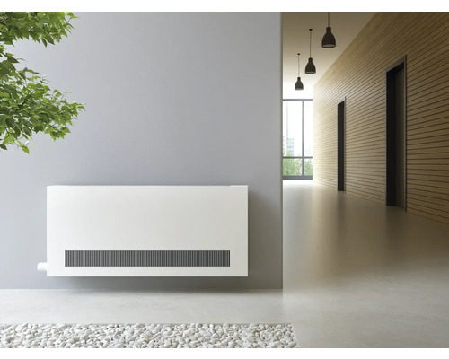 Weißer Heizkörper an einer grauer Mauer an engem helle Gank.