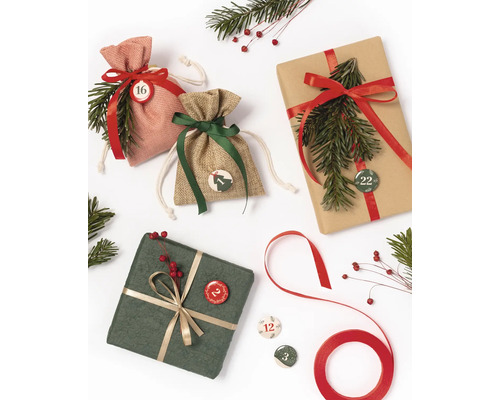 Weihnachtliche Szene mit Geschenken, Adventskalendertüten und Tannenzweigen
