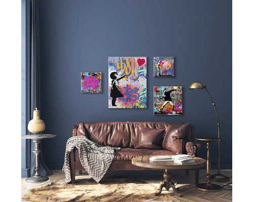 Wohnzimmer mit braunem Ledersofa, Holztisch und Wanddekoration mit Graffiti-Motiven