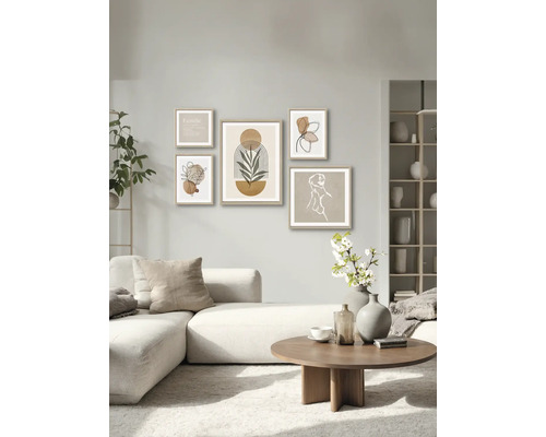 Wohnzimmer mit Sofa, Couchtisch und Wand mit fünf gerahmten Kunstdrucken