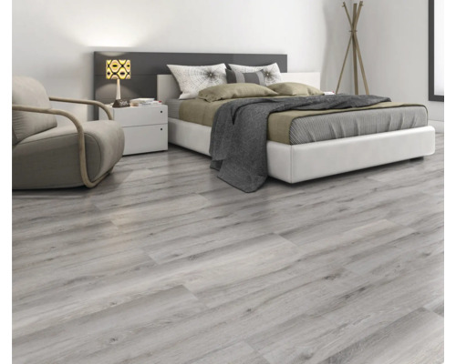 Heller Schlafraum mit Laminatboden in Holzoptik, Bett, Sessel und Nachttisch