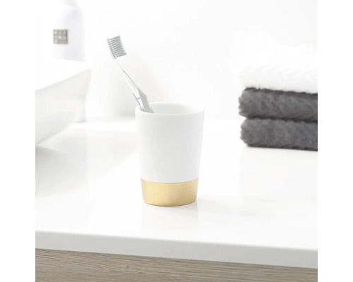Zahnbürste in einem Zahnputzbecher auf einer Badezimmeroberfläche