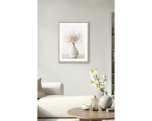 Image encadrée avec un vase de fleurs séchées dans le salon