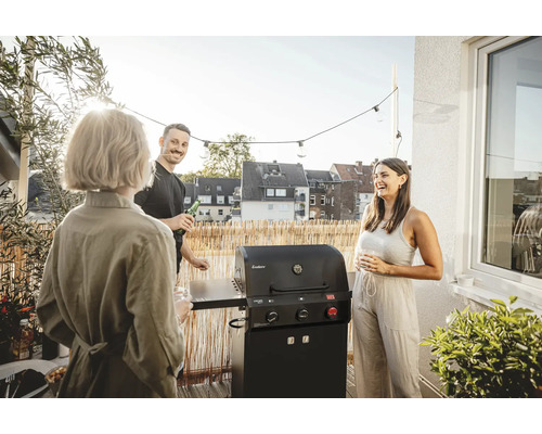 Scène sur un balcon avec des personnes et un barbecue à gaz noir de Enders