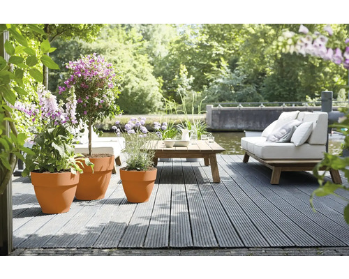 Terrasse am Wasser mit Pflanzgefäßen und Gartenmöbeln