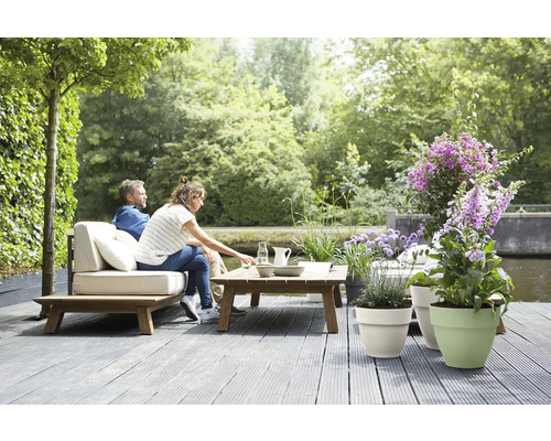 Szene im Garten mit Paar auf Gartenmöbeln, Tisch und verschiedenen Pflanzgefäßen