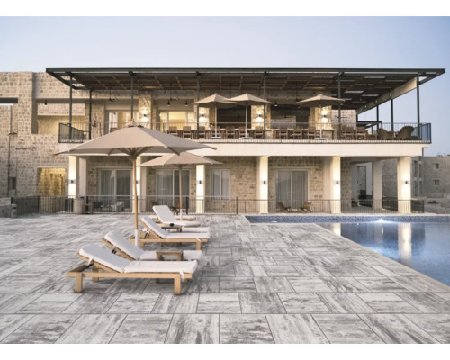 Vue extérieure d''un complexe hôtelier avec piscine, chaises longues et parasols