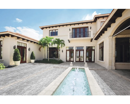 Außenansicht eines Hauses mit Pflastersteinen und Brunnen