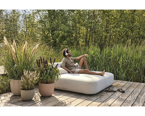 Scène avec des pots de fleurs plantés et une personne se détendant sur un banc de jardin à l''extérieur