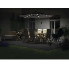 Terrasse éclairée avec table de jardin, chaises, parasol et barbecue