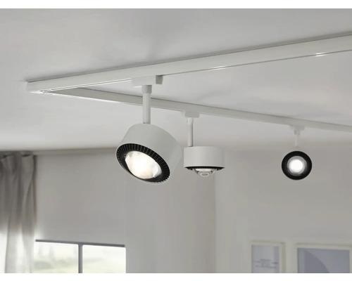 Weißes Schienensystem mit drei Strahlern an der Decke.