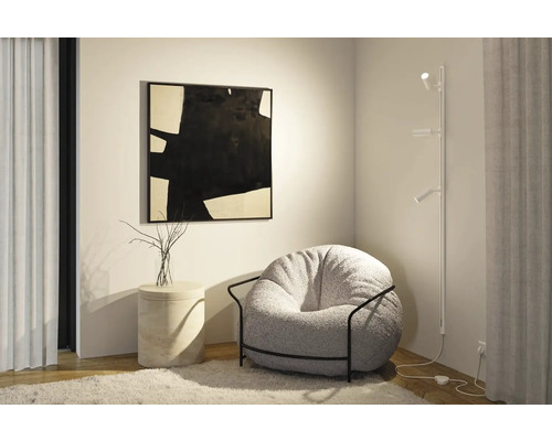 Wohnzimmer mit Sessel, Stehlampe und abstrakter Kunst